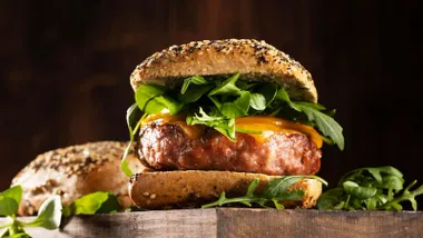 Hamburguesa gruesa con pan y verduras.