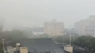 Niebla densa sobre la avenida de la Sanidad Pública en Cádiz, con los edificios apenas visibles entre la bruma matinal.