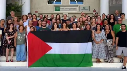 Alumnos y profesores del IES Manuel de Falla posan junto a la bandera de Palestina.