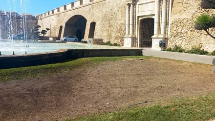 Vista general de los parterres situados junto a Puerta de Tierra completamente secos y sin vegetación, con la tierra desnuda y sin rastro de flores tras el desmontaje del escenario del espectáculo final de Cádiz Romana.