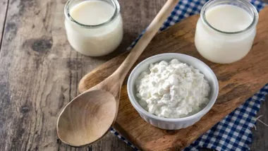Kefir y vasos con este producto junto a un cucharón de madera.