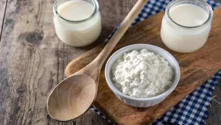 Kefir y vasos con este producto junto a un cucharón de madera.
