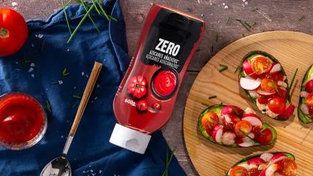 Bote de Ketchup Zero con tomates frescos junto al mismo.