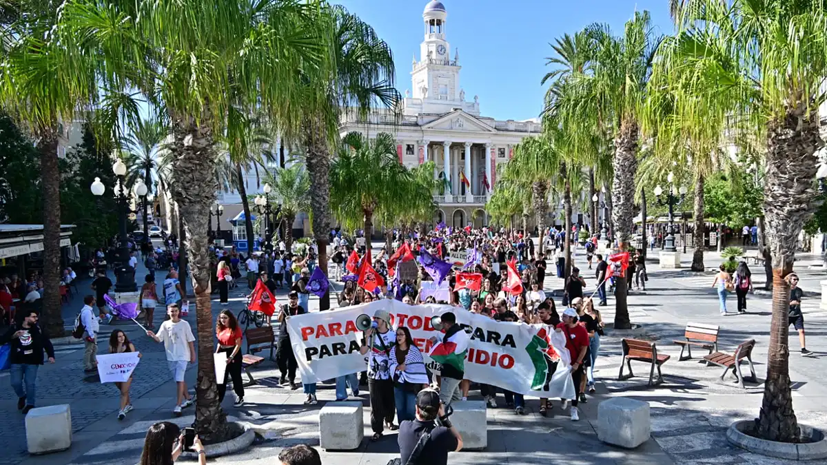 Grupo de estudiantes en la huelga del 2 de octubre saliendo de la Plaza de San Juan de Dios de Cádiz, con el edificio del Ayuntamiento al fondo.