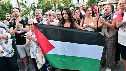 Una manifestante con una bandera de Palestina con otras personas detrás en una de las concentraciones celebradas en Cádiz.