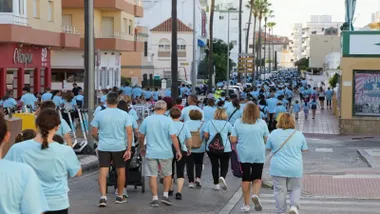 Muchas personas con camisetas celestes en la marcha contra el cáncer en Rota.