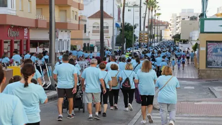 Muchas personas con camisetas celestes en la marcha contra el cáncer en Rota.