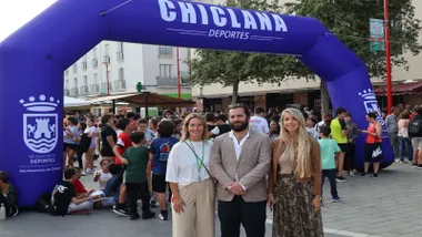 Los delegados del ayuntamiento de Chiclana posan delante de la meta de la marcha en color azul y letras blancas.