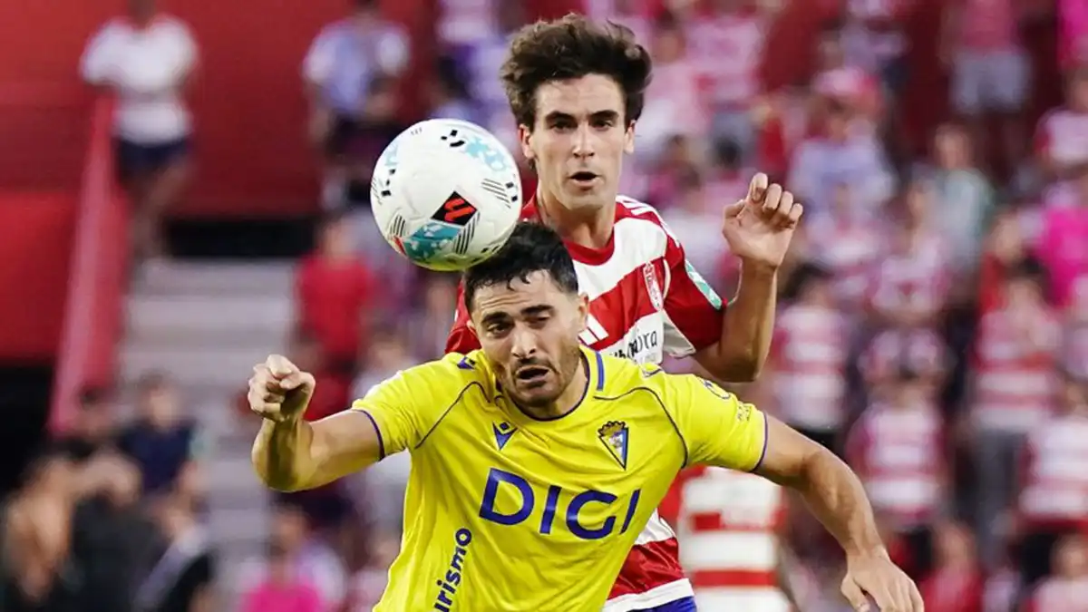 El jugador del Cádiz CF Ortuño recibe una carga de un defensa del Granada CF