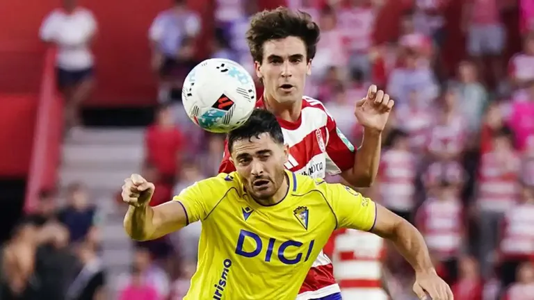 El jugador del Cádiz CF Ortuño recibe una carga de un defensa del Granada CF