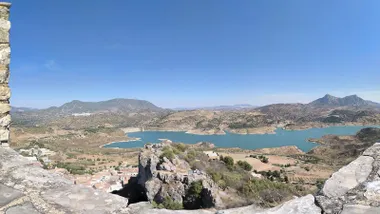 Embalse de Zahara-El Gastor visto desde la Torre del Homenaje, con agua azul, montañas y cielo despejado.