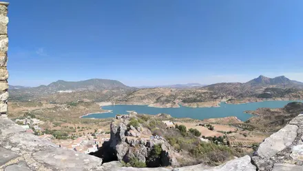 Embalse de Zahara-El Gastor visto desde la Torre del Homenaje, con agua azul, montañas y cielo despejado.