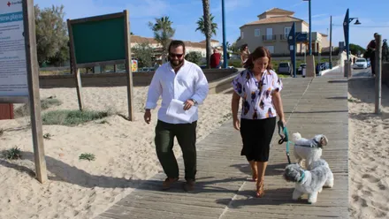 Ana González y Guillermo Sierra paseando unos perros por la playa en Chiclana.