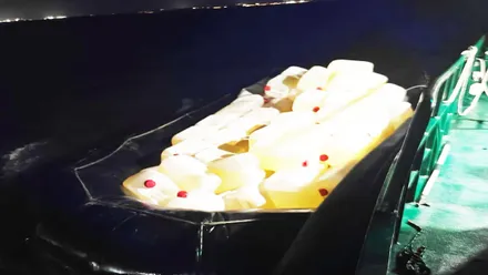 Lancha neumática sobrecargada con bidones de combustible.