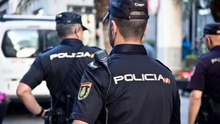Grupo de tres policías nacionales en una calle.