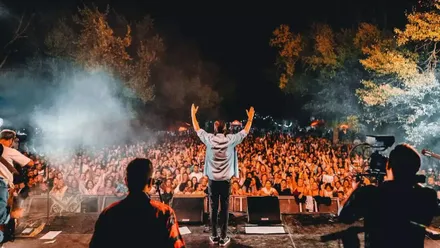 Cantante saludando al público en SIERRASUR 2025.