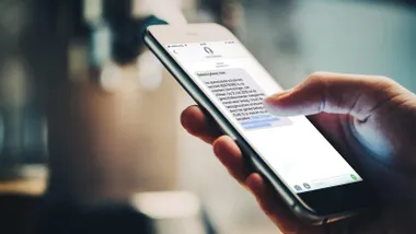 Mano manipulando la pantalla táctil de un teléfono móvil.