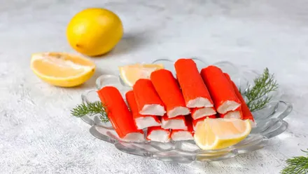 Plato con una torre de surimi y tras este un limón.