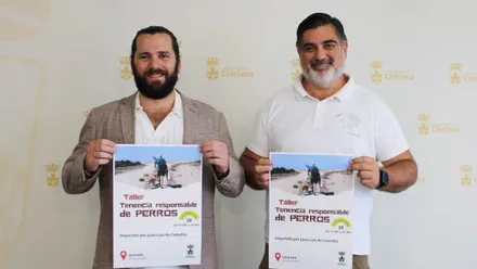 Responsables del taller sosteniendo el cartel en las manos.