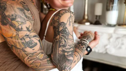 Un hombre y una mujer con tatuajes en los brazos.