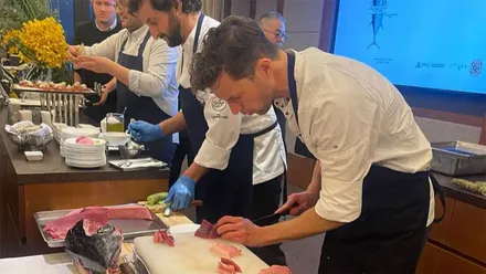 Varios cocineros de TohQa trabajan en una cocina profesional mientras preparan piezas de atún rojo, en una fotografía compartida por el restaurante en su página de Facebook.
