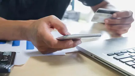 Persona frente al ordenador realizando una transferencia.