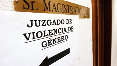 Placa de Magistrado y un folio señalando la dirección del Juzgado de Violencia de Género.
