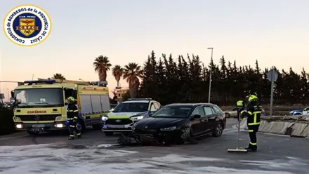 Vehículo de bomberos junto al coche siniestrado en la rotonda.