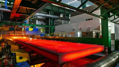 Pieza de acero ecológico incandescente saliendo del horno.