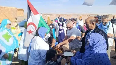 Fotografía tomada en los campamentos de Tinduf con un grupo de representantes de Adelante Andalucía caminando junto a autoridades saharauis