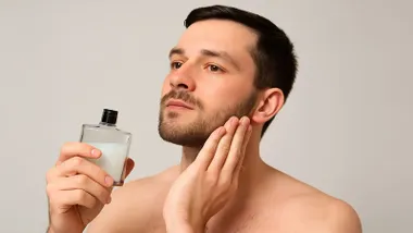 Hombre aplicándose el aftershave.