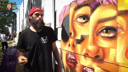 El onubense Alejandro Cristino Asuero con el mural con el que gano el IV Concurso de Arte Urbano de Dos Hermanas.