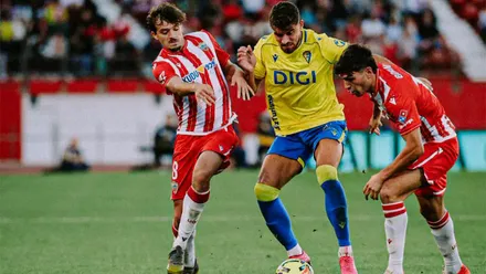 Álvaro García Pascual pelea un balón dividido entre dos defensas de la UD Almería durante una acción del encuentro en el Power Horse Stadium.
