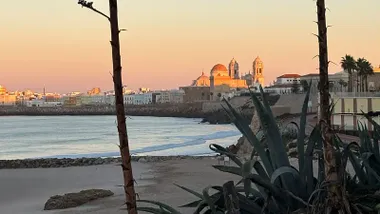 La catedral de Cádiz aparece iluminada por los rayos del amanecer en una día que comenzó despejado. Foto: José Luis Porquicho Prada.