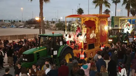 Carroza de un Rey Mago, tirada por un tractor, en Rota con mucho público.
