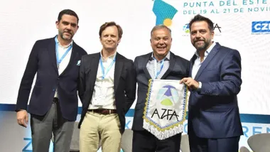 Los miembros de la comisión gaditana sonríen mientras sostienen el banderín en sus manos.