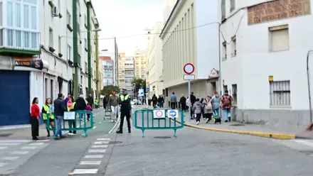 Fotografía tomada en la calle Trille durante la entrada del alumnado al Rebaño de María, mostrando las vallas de restricción, señales de tráfico y la patrulla escolar colaborando con agentes de la Policía Local. En el fondo, se aprecia la fachada del colegio y familias acompañando a los menores.