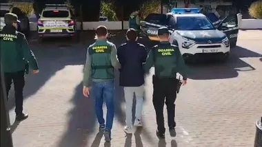 Dos agentes de la Guardia Civil con uno de los detenidos.