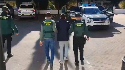 Dos agentes de la Guardia Civil con uno de los detenidos.