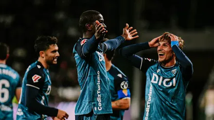 El jugador del Cádiz CF Moussa Dikite celebra su golazo ante el Córdoba CF con los brazos abiertos mientras De la Rosa, autor del primero, se lleva las manos a la cabeza. Foto: Cádiz CF.