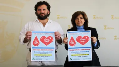 Delegado y representante sosteniendo el cartel para la donación de sangre.