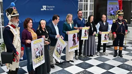 Presentación autoridades y participantes disfrazados del siglo XIX, con uniformes, sosteniendo el cartel.