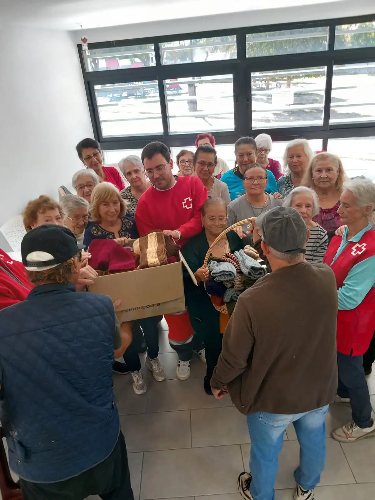 Entrega de un lote de bufandas a personas sin hogar de La Isla. Foto: Cruz Roja Cádiz.
