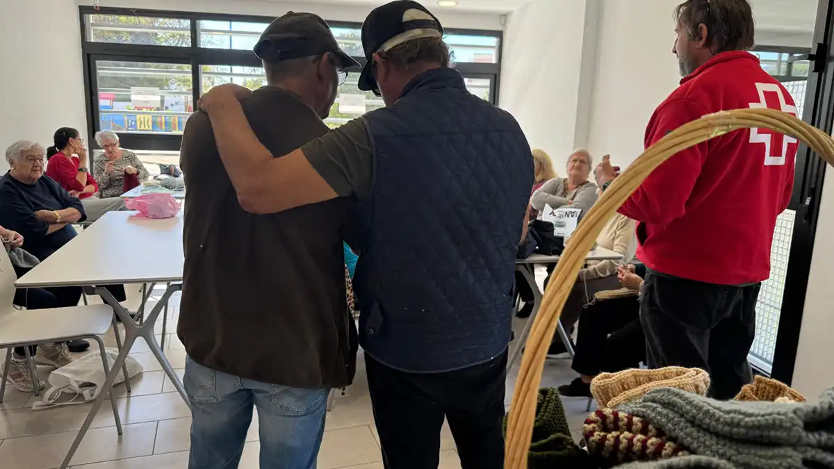 Dos personas sin hogar en un momento de la entrega de estas bufandas. Foto: Cruz Roja Cádiz.