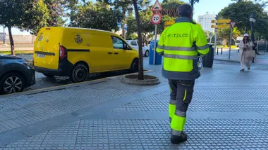 Una furgoneta de Correos aparcada en Cádiz mientras viandantes caminan por la acera