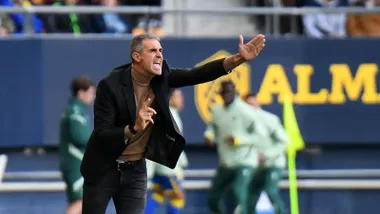 Imagen de Gaizka Garitano, entrenador del Cádiz CF, en la zona técnica del Nuevo Mirandilla. Aparece de pie junto a la línea de cal, gesticulando con el brazo derecho mientras da órdenes a sus jugadores. Viste ropa técnica del equipo y muestra un gesto serio y concentrado.