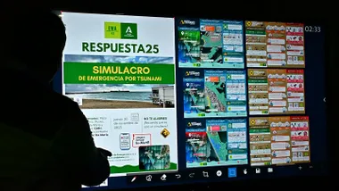 Técnico de emergencias mostrando en una pantalla el plan y las rutas del simulacro de tsunami en Cádiz.