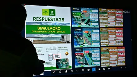 Técnico de emergencias mostrando en una pantalla el plan y las rutas del simulacro de tsunami en Cádiz.