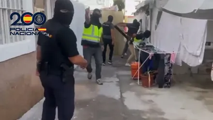 Agentes de la Policía Nacional enmascarados derribando una puerta de un punto de droga.