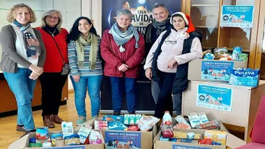 Cajas con libros y alimentos de la campaña "Libro Solidario" en Cádiz con sus responsables.